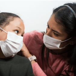 woman wearing face mask caring for daughter