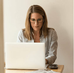 professional middle-aged woman with glasses working on a laptop
